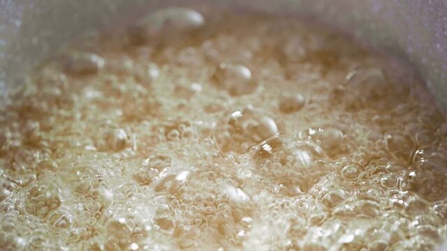 Close up view. Caramelizing sugar in saucepan to make homemade lollipops.