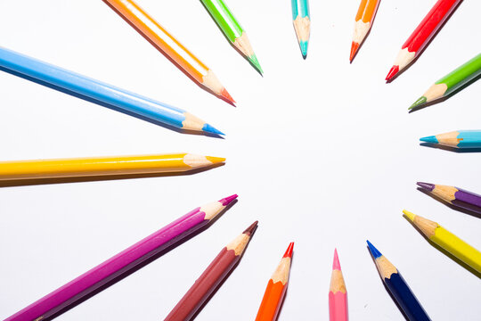 group of color pencils forming a circle on white background