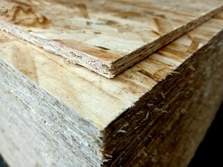 A stack of plywood sheets for construction. A pile of wooden chipboard sheets. Osb plywood.