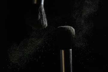 photography in a dark style, two brushes after a collision, backlight, scattered powder