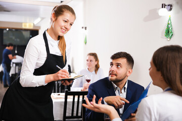 Couple is giving order to female waiter in luxury restaurante indoor.