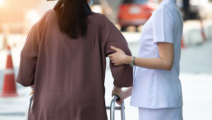 Nurse is helping Senior Elderly Asian Woman uses Zimmer frame walker