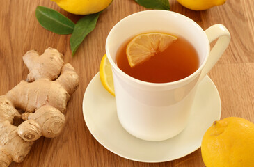 Hot black tea drink in white pocelain cup with lemon and ginger