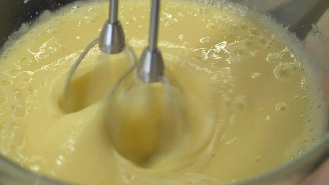 Close-up. Beat Cream with Mixer. Confectionery. Mixing. Yellow. Eggs and Sugar. Whisk. Cooking. Bakery. Coder. Cooking by Ourselves. Whisks Stir Cream Liquid. Cooking. Omelet. Breakfast. Pamper Family