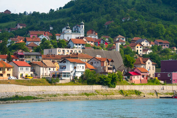 Fototapeta na wymiar Houses and Virgin Mary Church on the riverbank of the Drina River, Visegrad, Bosnia and Herzegovina
