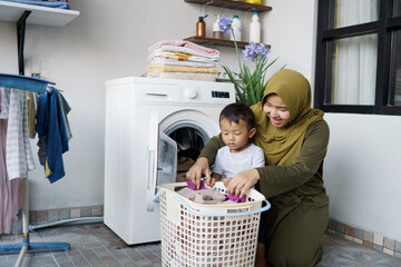 beautiful muslim asian woman doing laundry with her son together