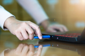 Hand  of woman connecting a Flash Drive to laptop computer on desktop for copy or transfer data.