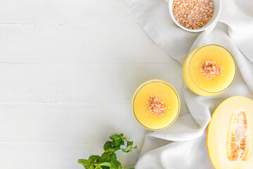 Glasses with melon smoothie on light background