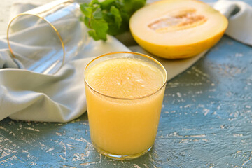 Glass with melon smoothie on grunge background