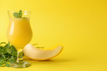 Glass with melon smoothie on color background