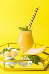 Tray with glass of melon smoothie on color background
