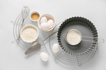 Set of kitchen utensils and ingredients for preparing bakery on light background