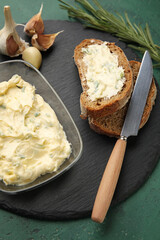 Tasty garlic butter and bread on color background