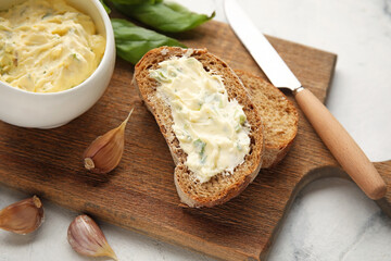 Slices of fresh bread with garlic butter on light background, closeup