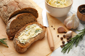 Slices of fresh bread with garlic butter on light background, closeup