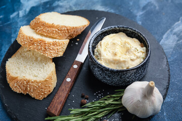 Slices of fresh bread, garlic butter and ingredients on color background, closeup