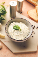 Bowl with tasty garlic butter and ingredients on color background