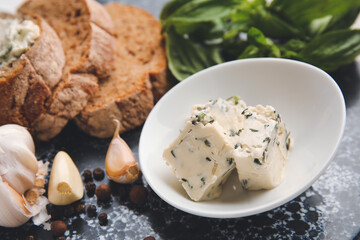 Bowl with tasty garlic butter, bread and spices, closeup