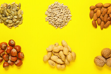 Different healthy nuts and seeds on color background