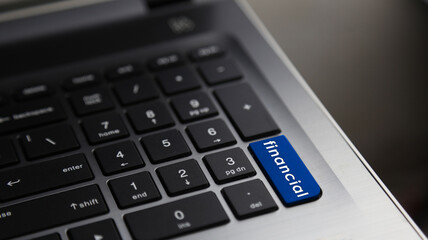 Fototapeta na wymiar Financial word on laptop keyboard blue button. Concept for business and financial.