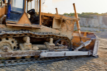 Fototapeta premium yellow excavator digs the ground in nature and sun summer sand