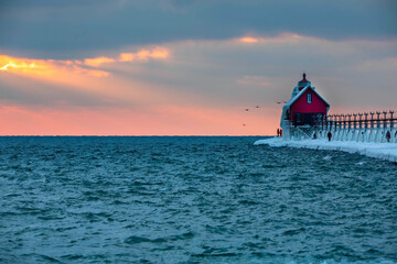 Fototapeta na wymiar Grand Haven lighthouse sunset on Lake Michigan in winter