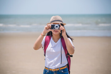 portrait of a girl with a camera on the beach