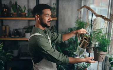 Shop assistant working in indoor potted plant store, small business concept.