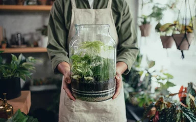 Foto op Canvas Shop assistant holding terrarium in indoor potted plant store, small business concept. © Halfpoint