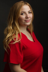 a blonde girl with an overweight plus size, a red overallposing on a dark Studio background