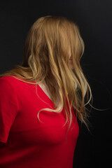 a blonde girl with an overweight plus size, a red overallposing on a dark Studio background