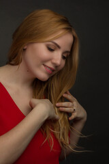 a blonde girl with an overweight plus size, a red overallposing on a dark Studio background