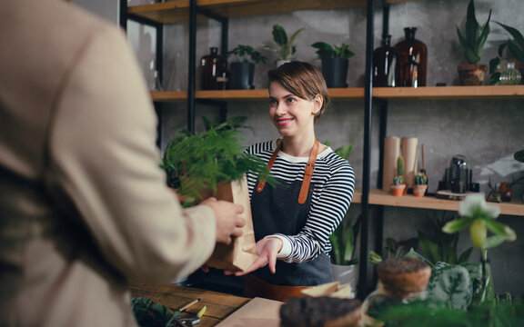 Shop Assistant Serving Customer In Indoor Potted Plant Store, Small Business Concept.