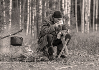 landscape with a forester in the woods by the fire, a worker drinks tea and warms up by the fire, sepia