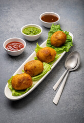 bread rolls stuffed with potatoes served with green and red sauces