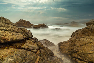 Long exposure water, beautiful seascape, ocean views, rocky coastline, sunlight on the horizon. Composition of nature. Sunset scenery background. Cloudy sky. California coast.