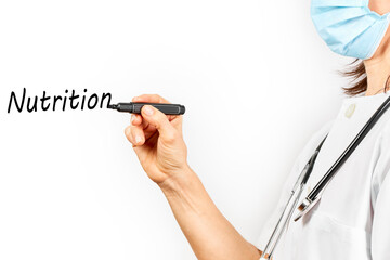 Doctor with mask writing the word nutrition on a white background