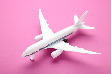 Model airplane on pink pastel color background.