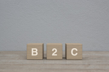 B2C letter on block cubes on wooden table over white wall background, Business to customer marketing and strategy concept