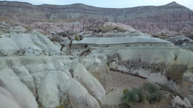 Aerial Reveal Rose Valley Rainbow Red Rock Canyon Landscape Cappadocia Turkey Cloudy Winter Morning (Drone - 4K)