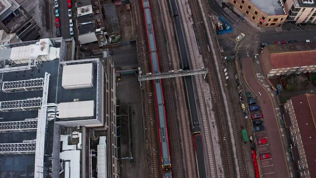 Pan up follow drone shot of Train pulling into London Waterloo station