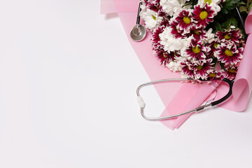 Stethoscope and bouquet of flowers on white table background, space for text. World health day