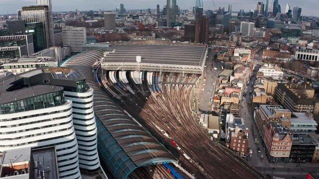 Dolly back pan up aerial drone shot of London Waterloo train station