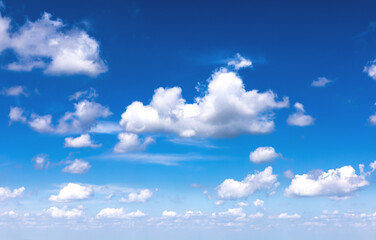 Beautiful blue sky background with sparse white clouds. Panorama. Copy space.
