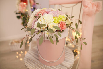Beautiful bouquet of flowers in pink round box. Gift for holiday, Women's Day, birthday, Wedding, Mother's Day, Valentine's day. Floral arrangement in a hat box.