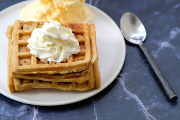 waffle with butter and cream on table background