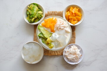 a glass of es teler or various fruits with coconut milk soup and ice cubes