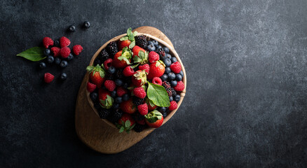 Fototapeta na wymiar Berries in bowl on rustic background