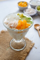 a glass of es teler or various fruits with coconut milk soup and ice cubes