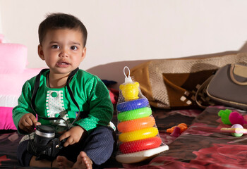 Asian Indian baby girl portrait closeup playing with toys. A cute baby girl .